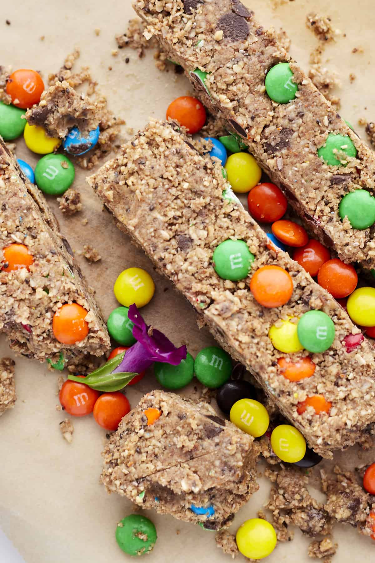 overhead closeup of monster cookie bars with mms over brown parchment paper