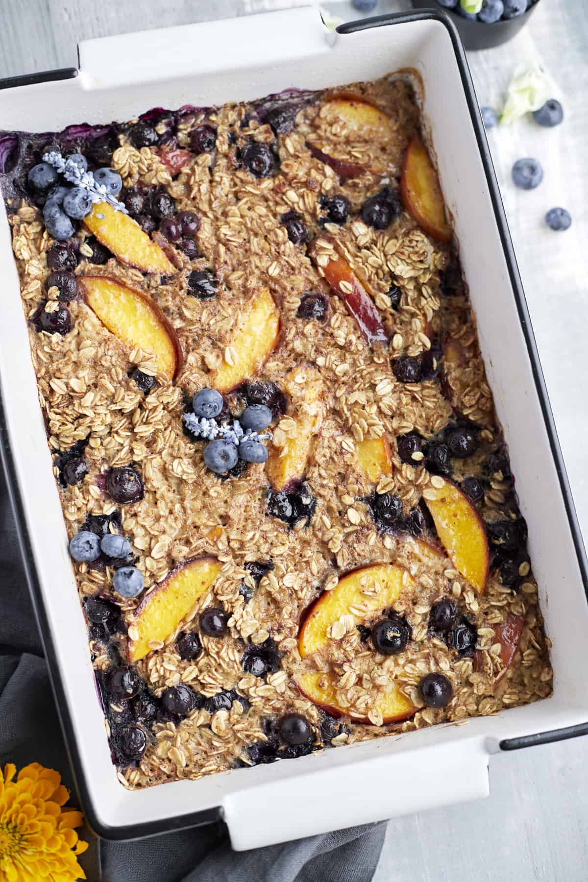 overhead image of a rectangular baking dish full of peach blueberry baked oats
