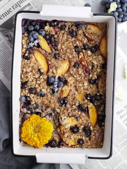 Overhead image of peach blueberry baked oats in a baking dish.