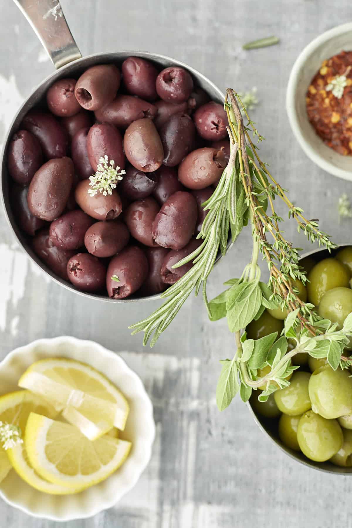 red olives, green olives, spices, and lemon wedges