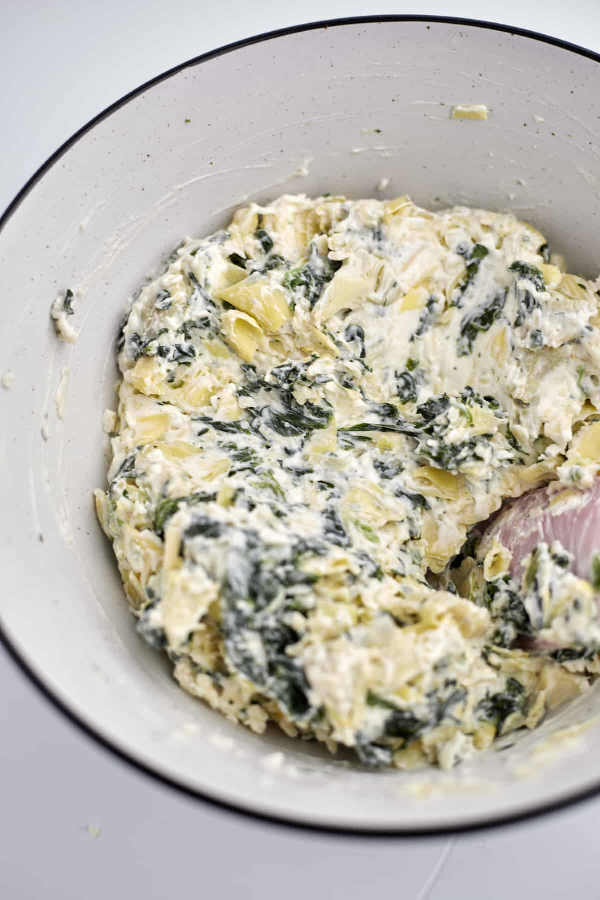 spinach and artichoke mixture in a white bowl 