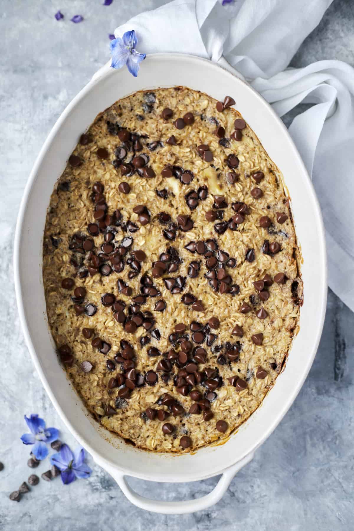 Baked Banana Bread Oatmeal in a baking dish topped with dark chocolate chips