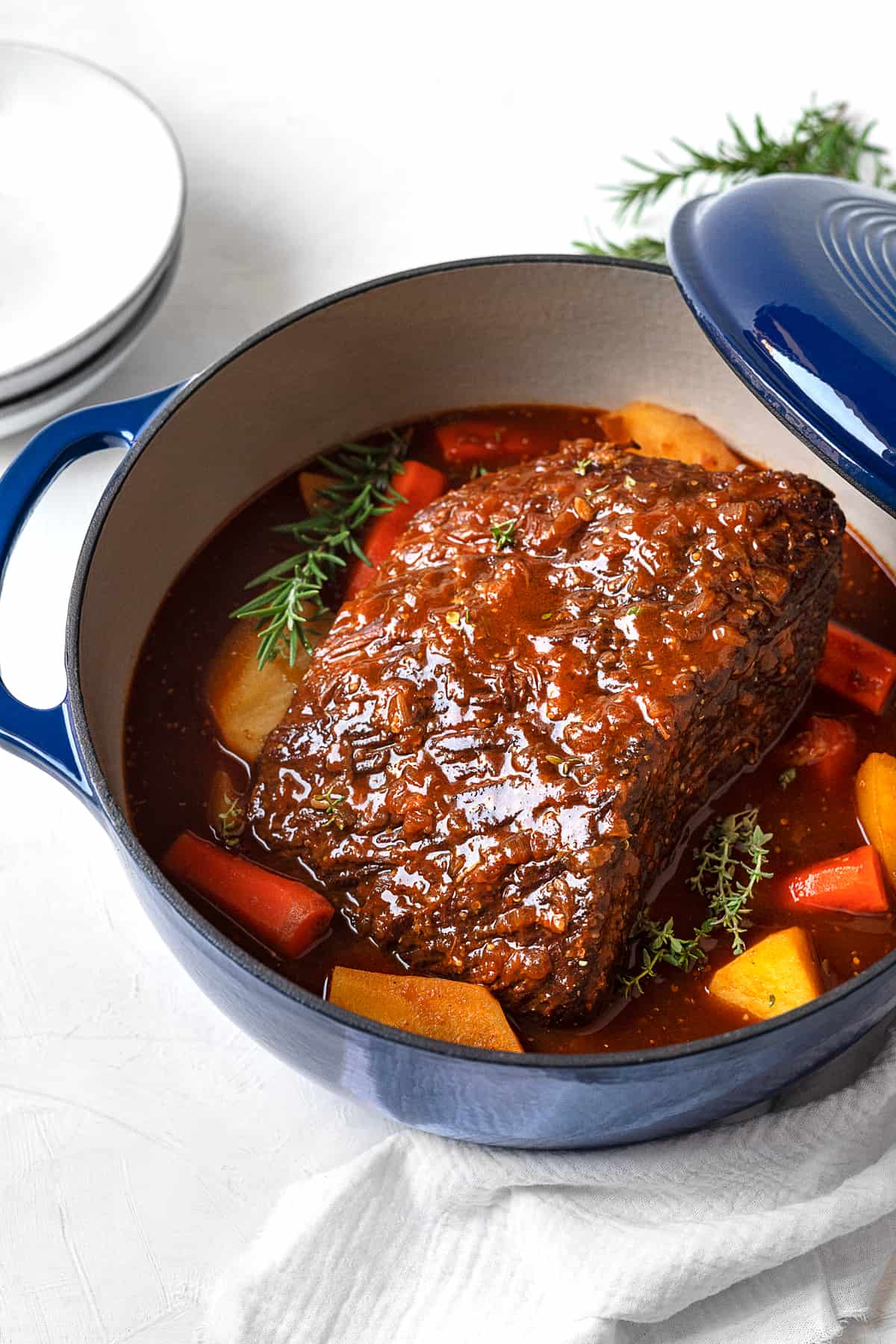 fully cooked beef pot roast in a dutch oven with potatoes and carrots