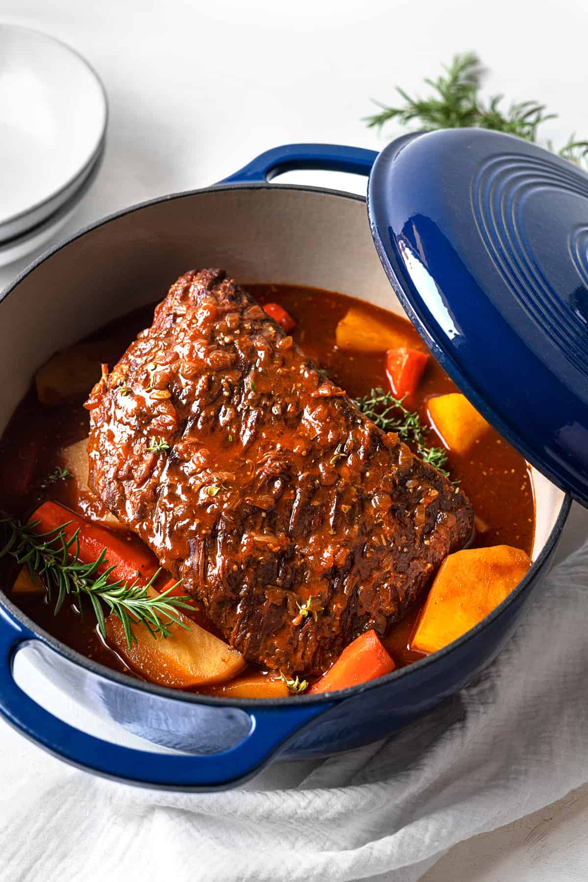 cooked beef pot roast in a dutch oven with potatoes and carrots