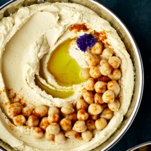 Hummus topped with olive oil and chickpeas.