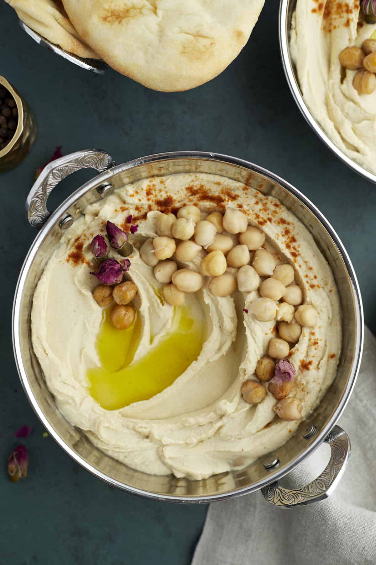 overhead image of a pot of chickpea hummus topped with chickpeas, olive oil, and seasonings