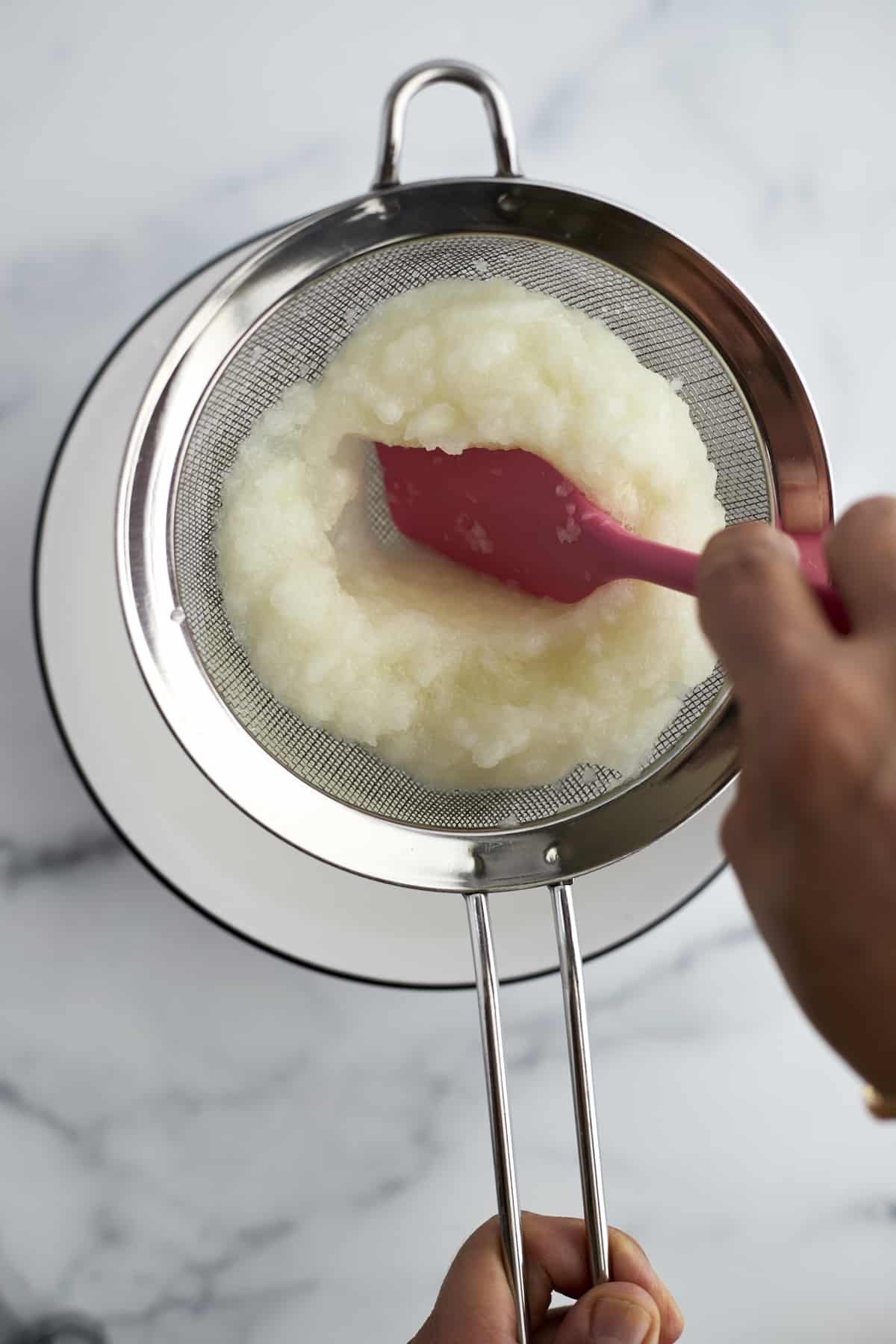 pureed onions being strained