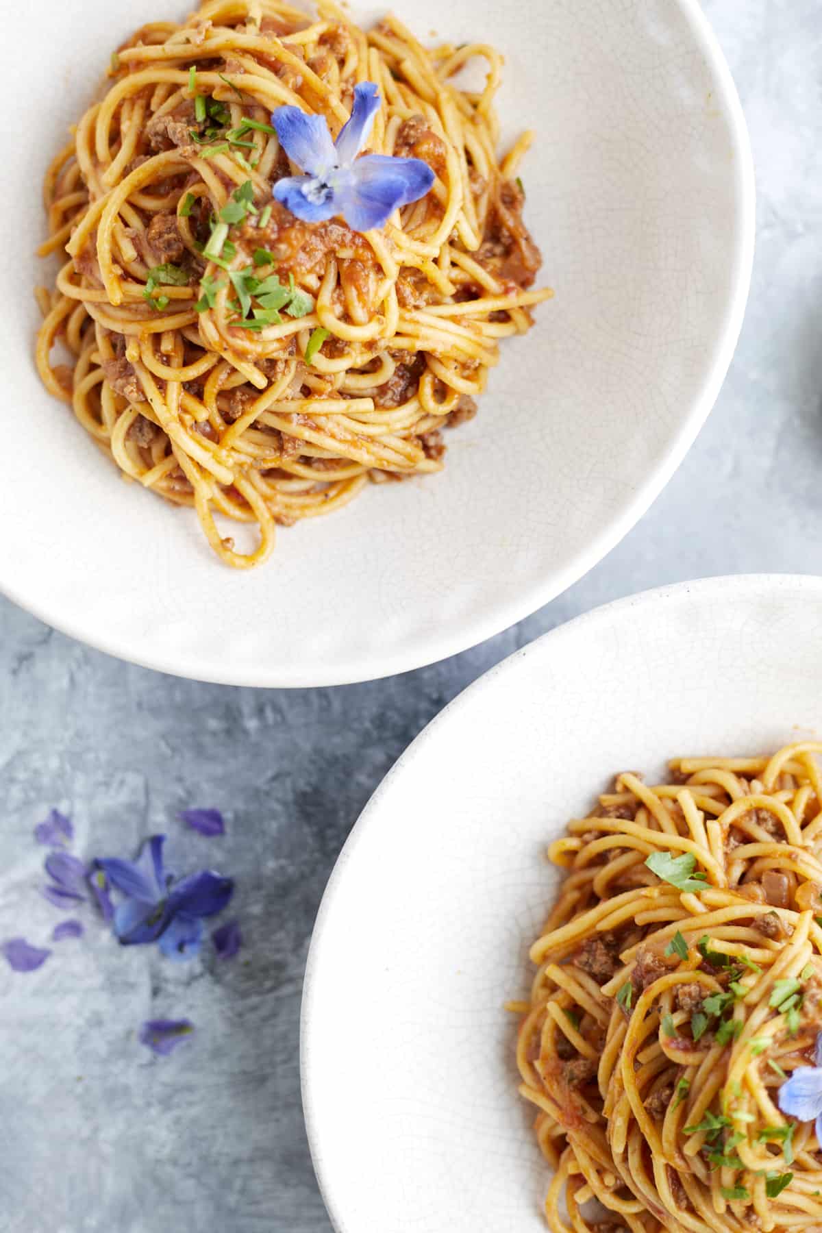 overhead image of two white bowls full of one pot spaghetti recipe with ground beef.