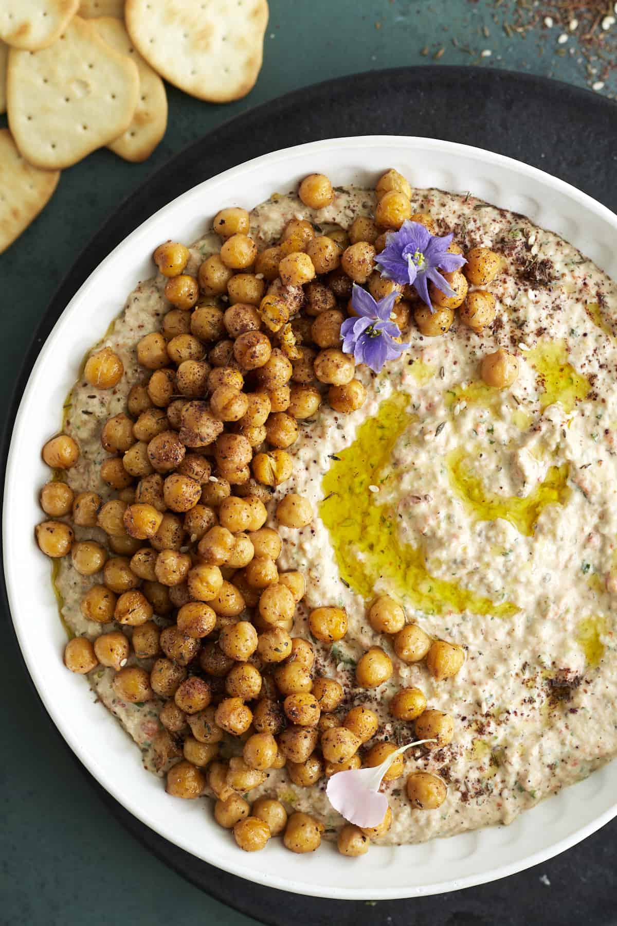 a white bowl full of an easy baba ganoush recipe topped with crispy chickpeas and olive oil