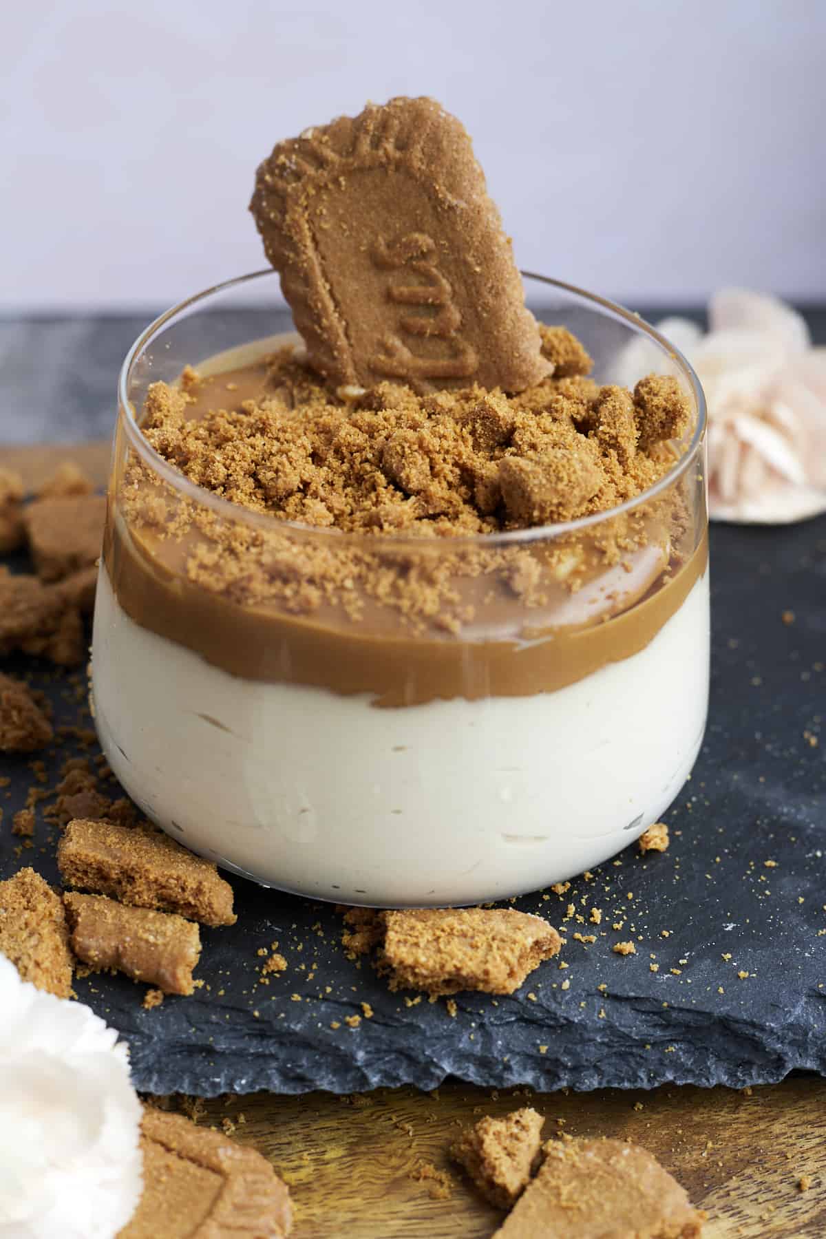 a glass jar with Biscoff mousse topped with Biscoff spread and Biscoff cookie pieces with a cookie sticking out