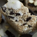 close up image of the side of an Oreo Rice Krispie Treat layered with chocolate chips, Oreo chunks, and marshmallow fluff