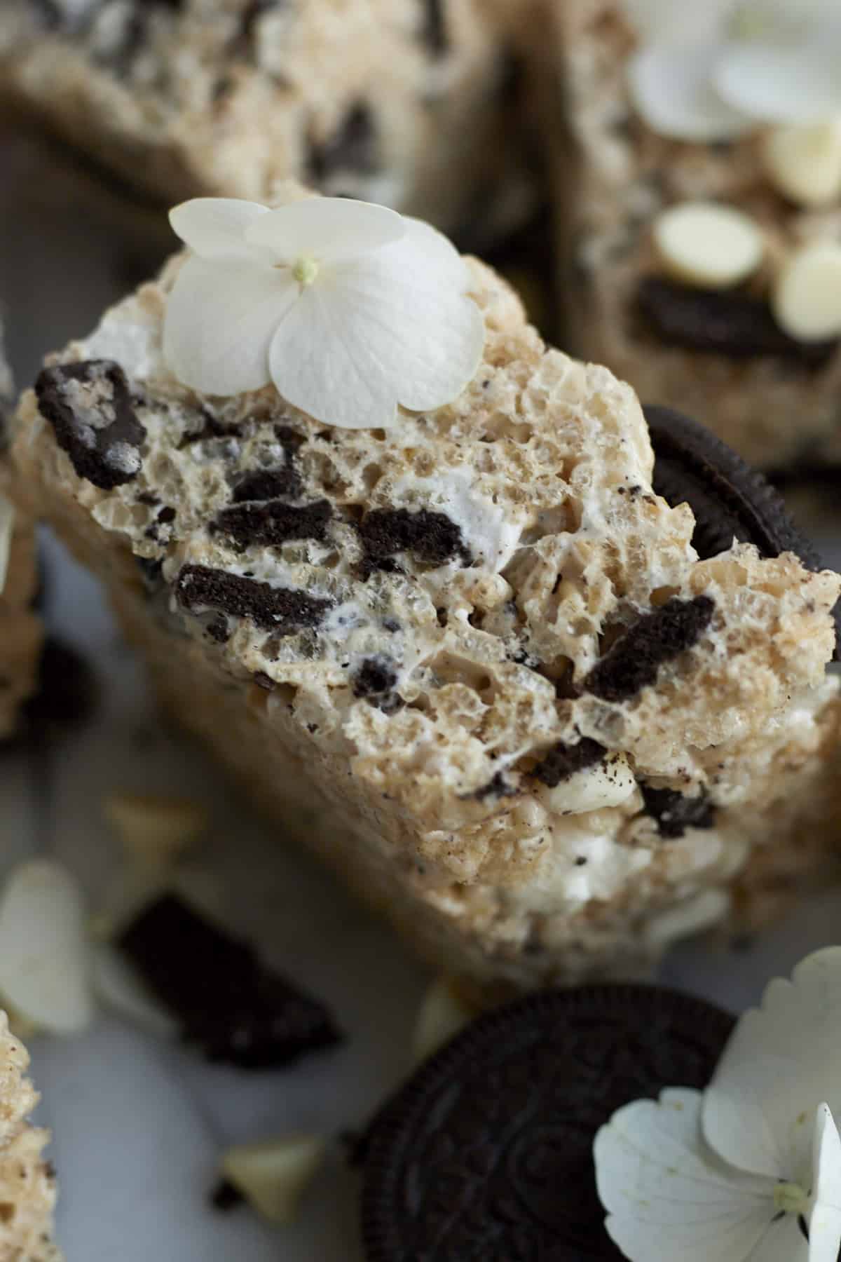 close up image of the side of an Oreo Rice Krispie Treat layered with chocolate chips, Oreo chunks, and marshmallow fluff