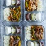 4 chipotle chicken meal prep boxes with onions, peppers, and sides of salsa, guacamole, and sour cream.