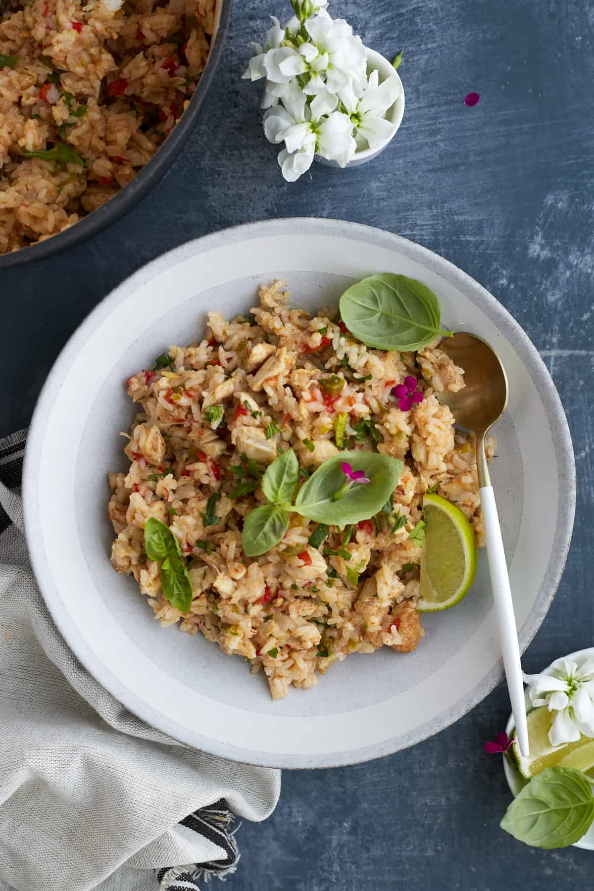 overhead image of a bowl full of fajita seasoned rice with a pot of the rice in the top lefthand corner