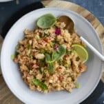overhead image of a bowl of one pot fajita seasoned rice topped with fresh herbs and lime wedges