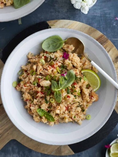 overhead image of a bowl of one pot fajita seasoned rice topped with fresh herbs and lime wedges