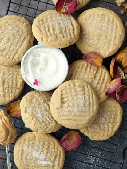 soft peanut butter cookies on a wire rack with a bowl of sugar in the center
