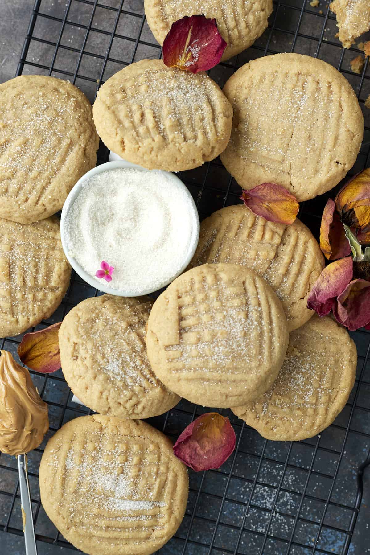 soft peanut butter cookies on a wire rack with a bowl of sugar in the center