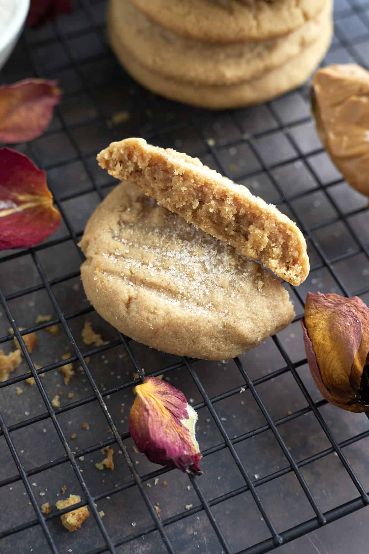 a soft peanut butter cookie broken in half on a wire rack