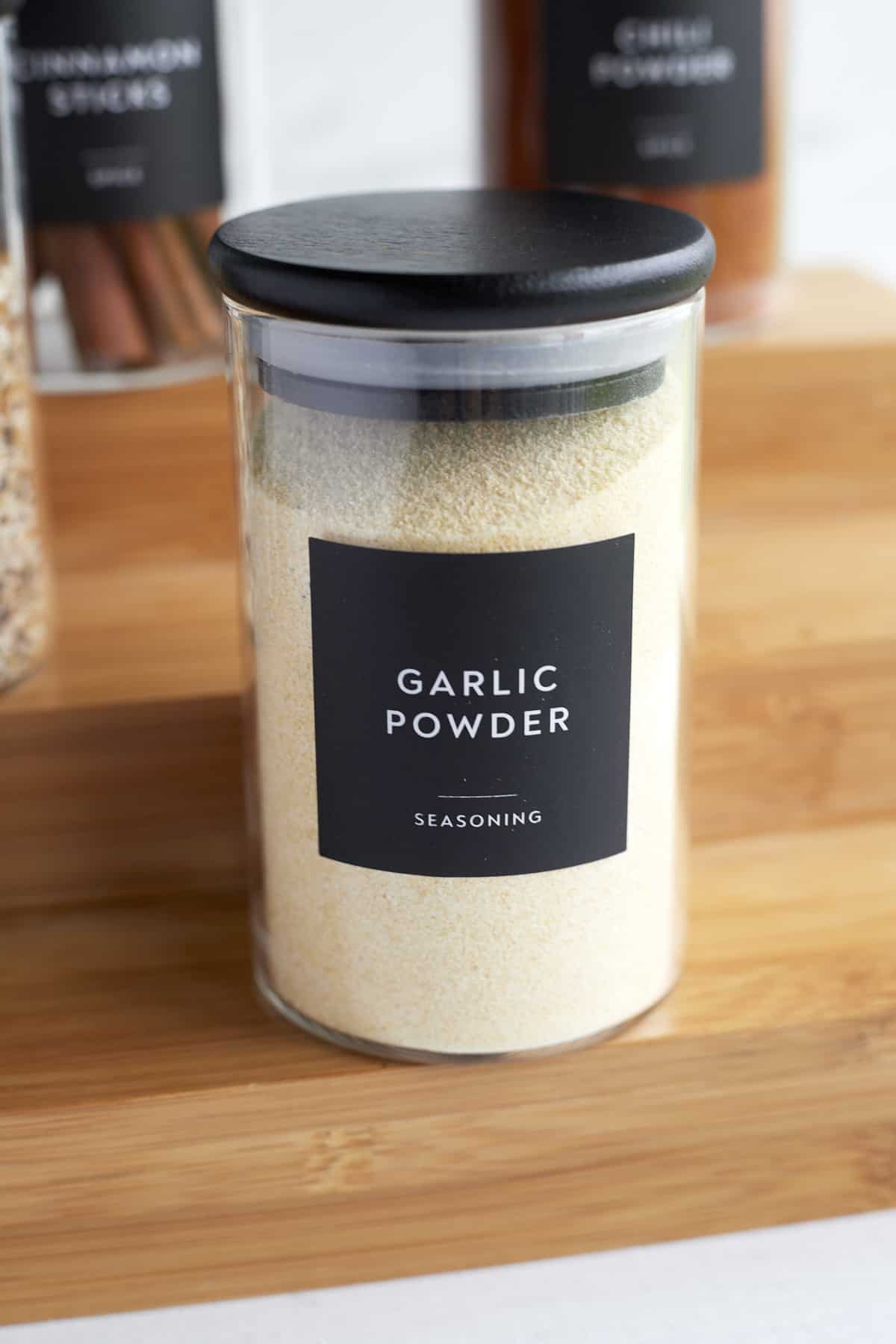 a clear bottle full of garlic powder with a black label on the front