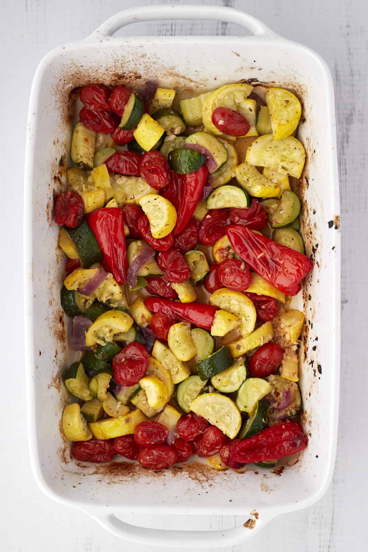 overhead image of cooked veggies in a white baking dish