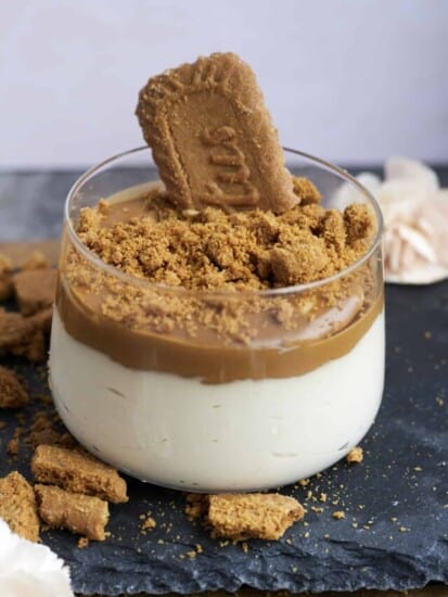 a glass jar with Biscoff mousse topped with Biscoff spread and Biscoff cookie pieces with a cookie sticking out