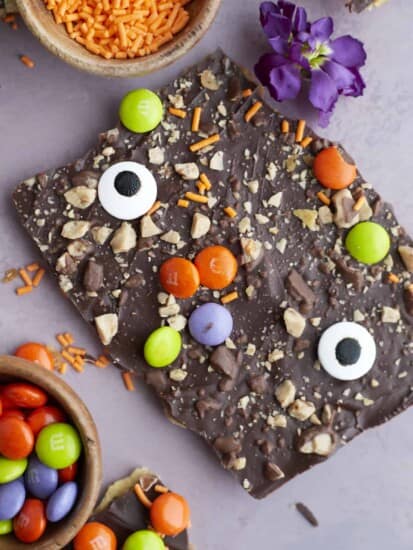 two pieces of Halloween saltine crack candy decorated with toffee, M&Ms, and candy eyeballs