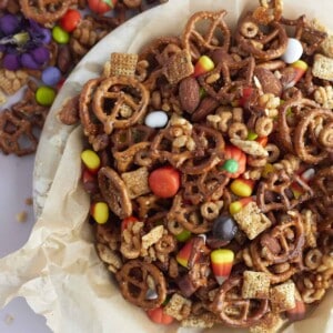a basket of halloween snack mix with cereal, pretzels, and candy