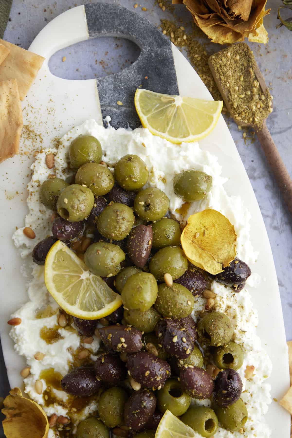 a feta board topped with marinated olives.