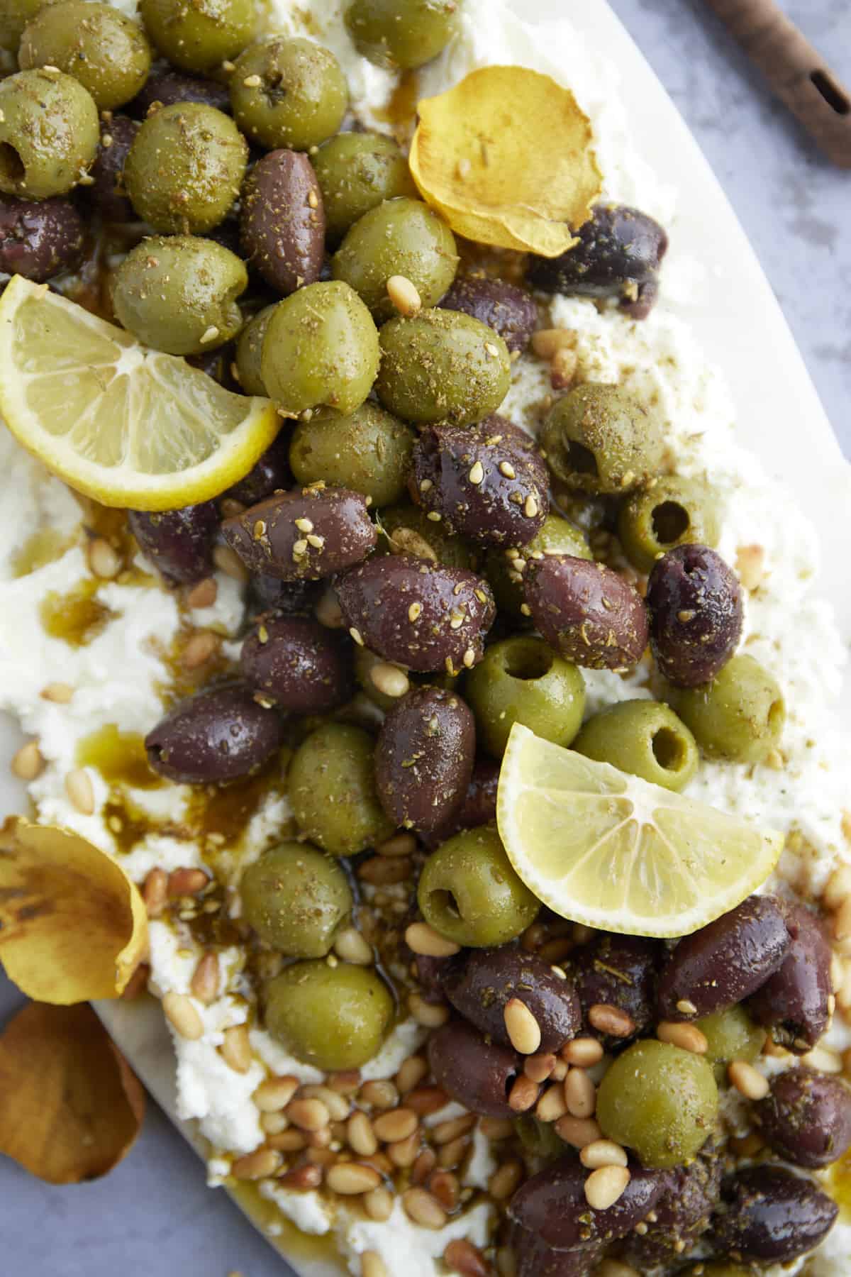 close up image of a feta board with marinated olives.