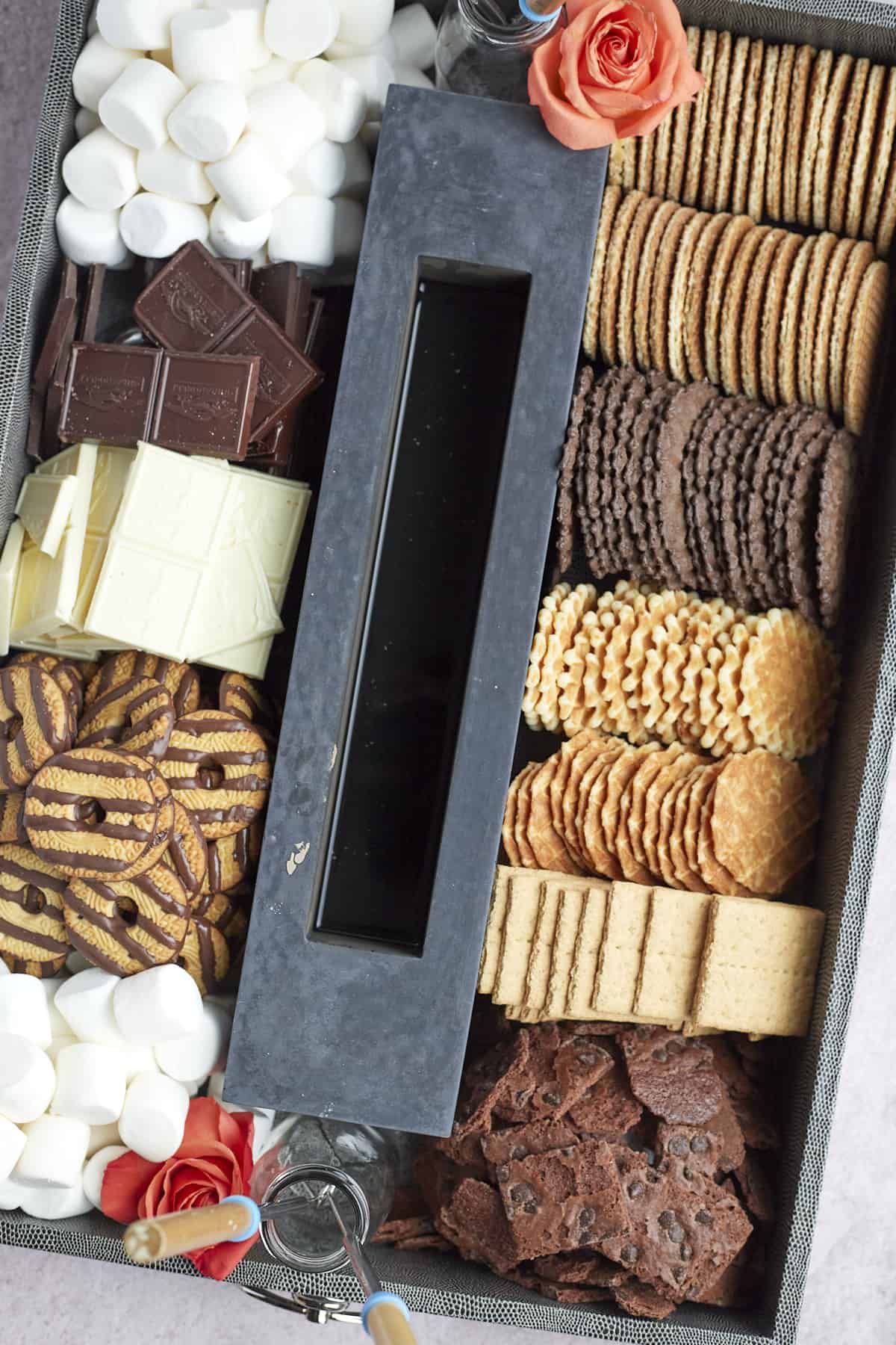 indoor smores board made with a portable fire pit, cookies, marshmallows, chocolate, and more