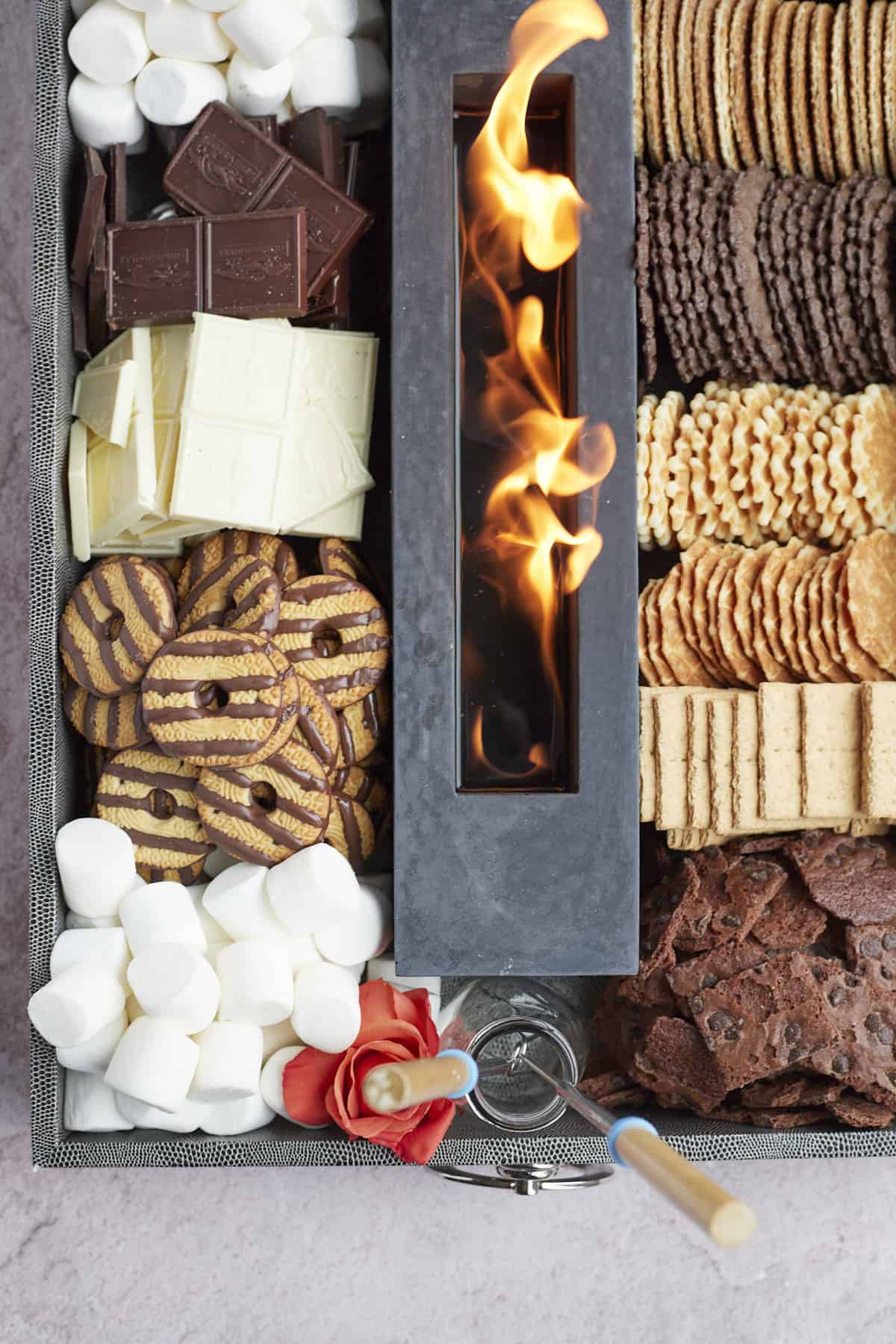 overhead image of a large indoor smores board with cookies, marshmallows, graham crackers, etc. 