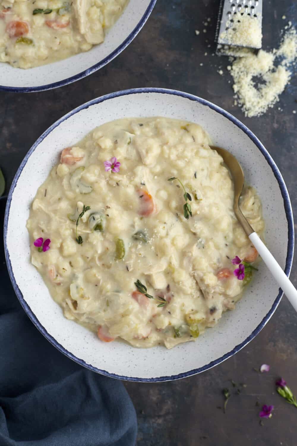 a bowl of creamy chicken noodle soup with a spoon sticking out of the side.