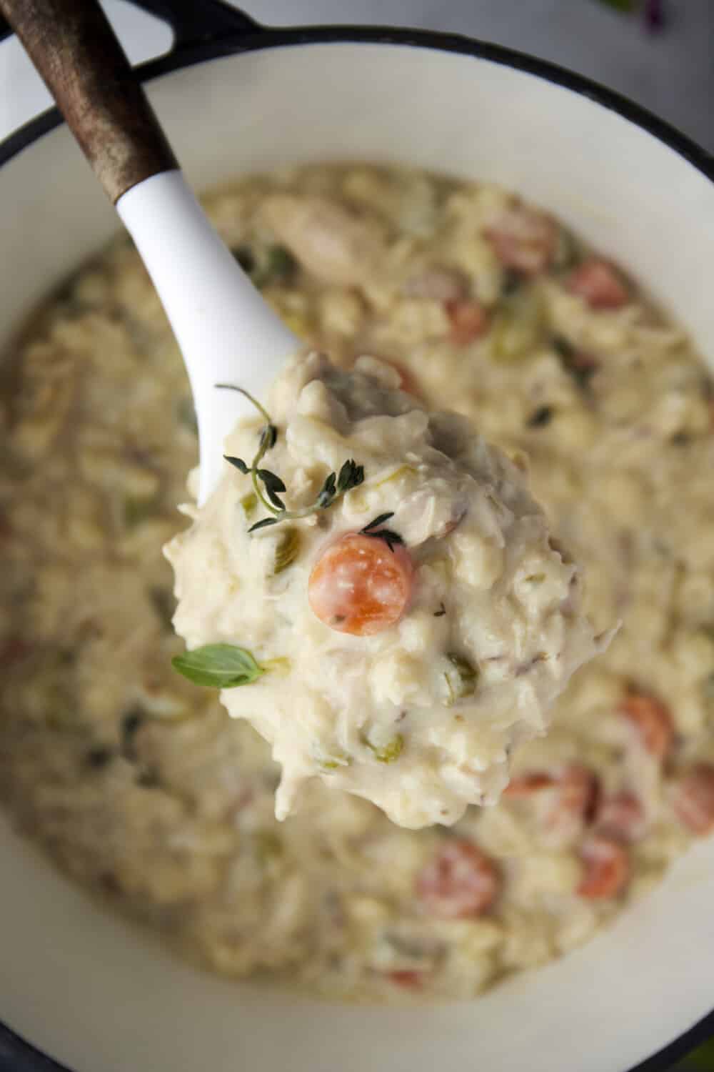 a spoonful of creamy chicken noodle soup over a bowl of soup.