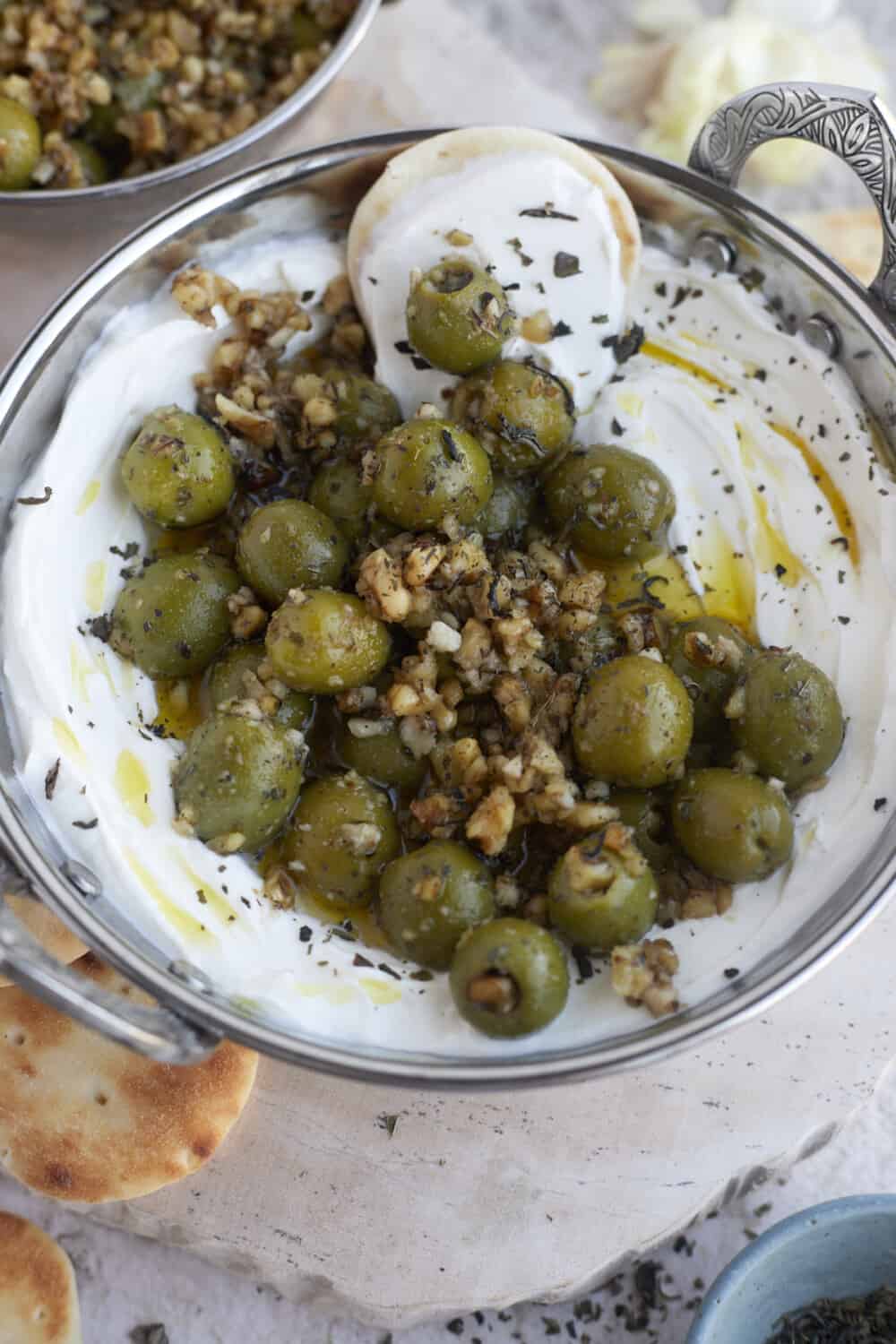 labne topped with marinated olives and pine nuts with crostini on the side