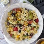 a large white bowl full of Italian pasta salad