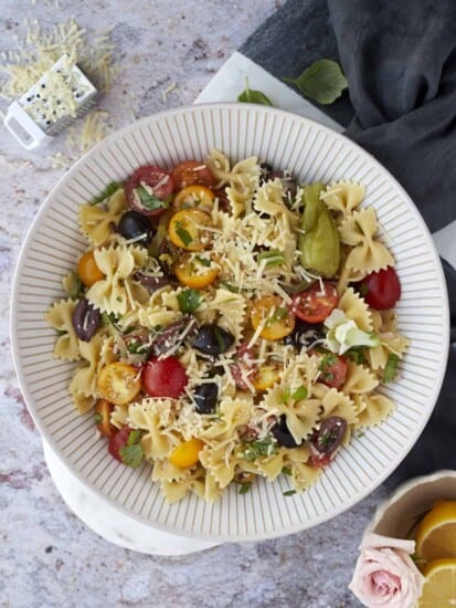 a large white bowl full of Italian pasta salad
