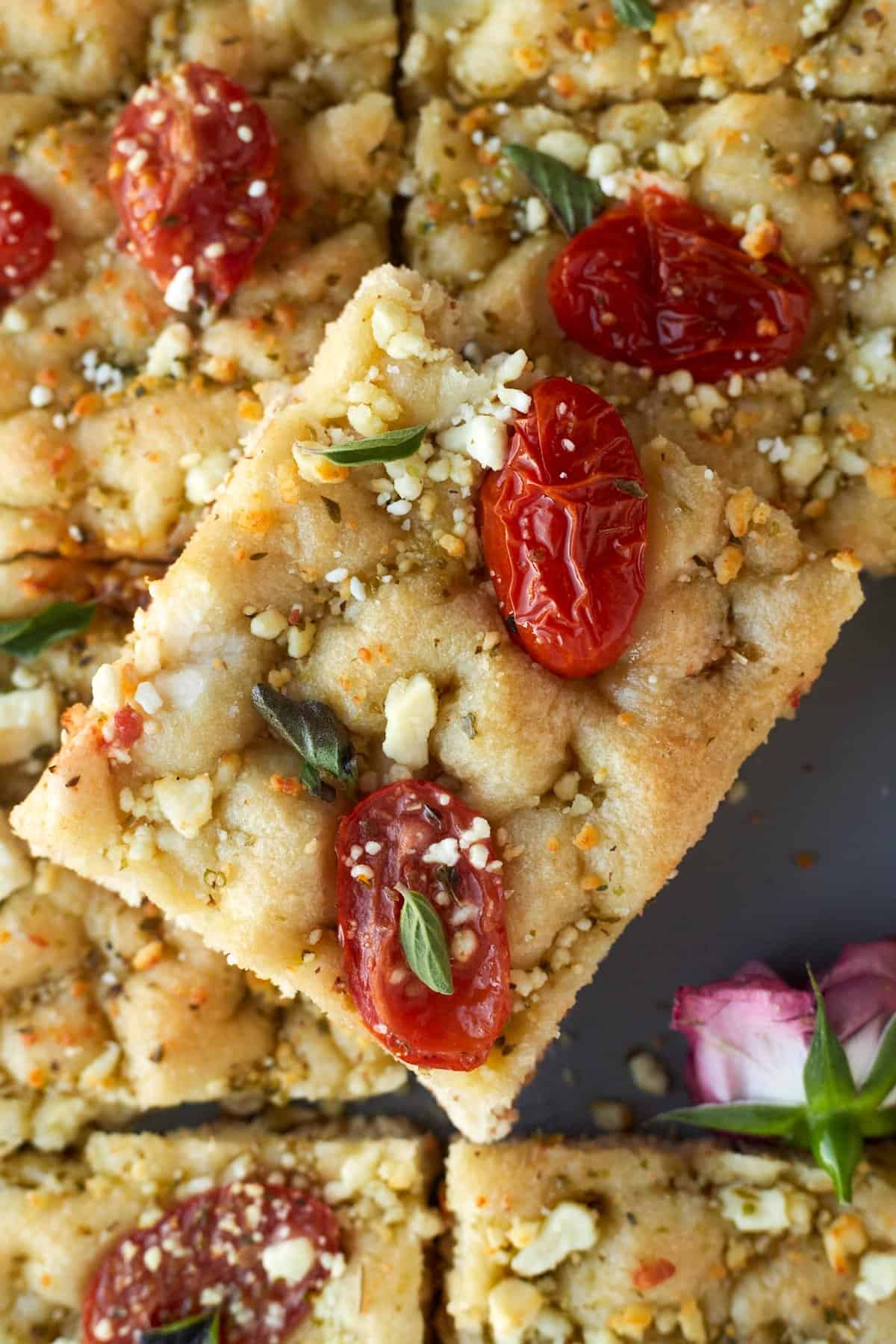 A slice of easy focaccia with tomatoes and feta