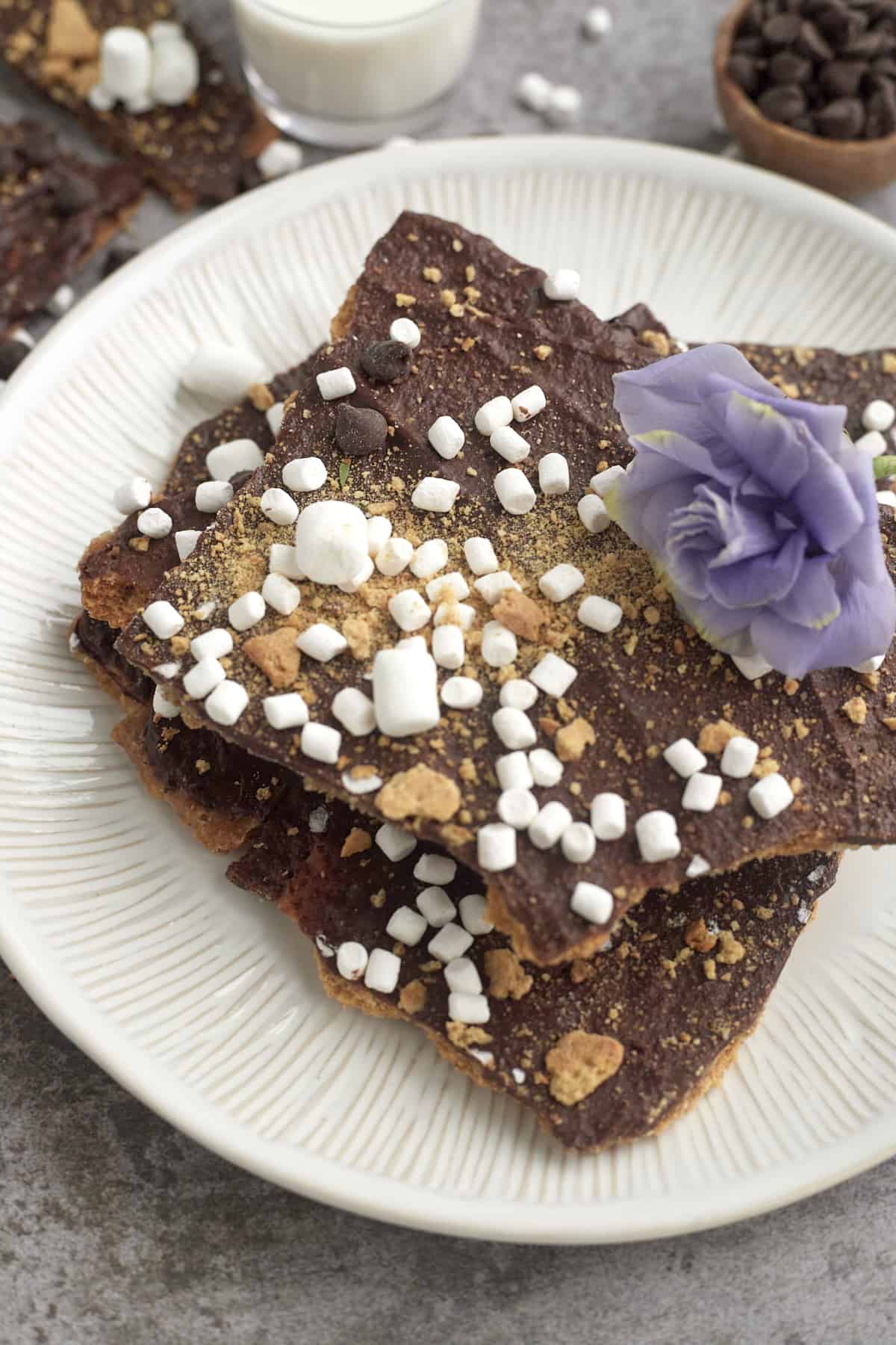 S'mores graham cracker toffee bars stacked on top of each other on a white plate 