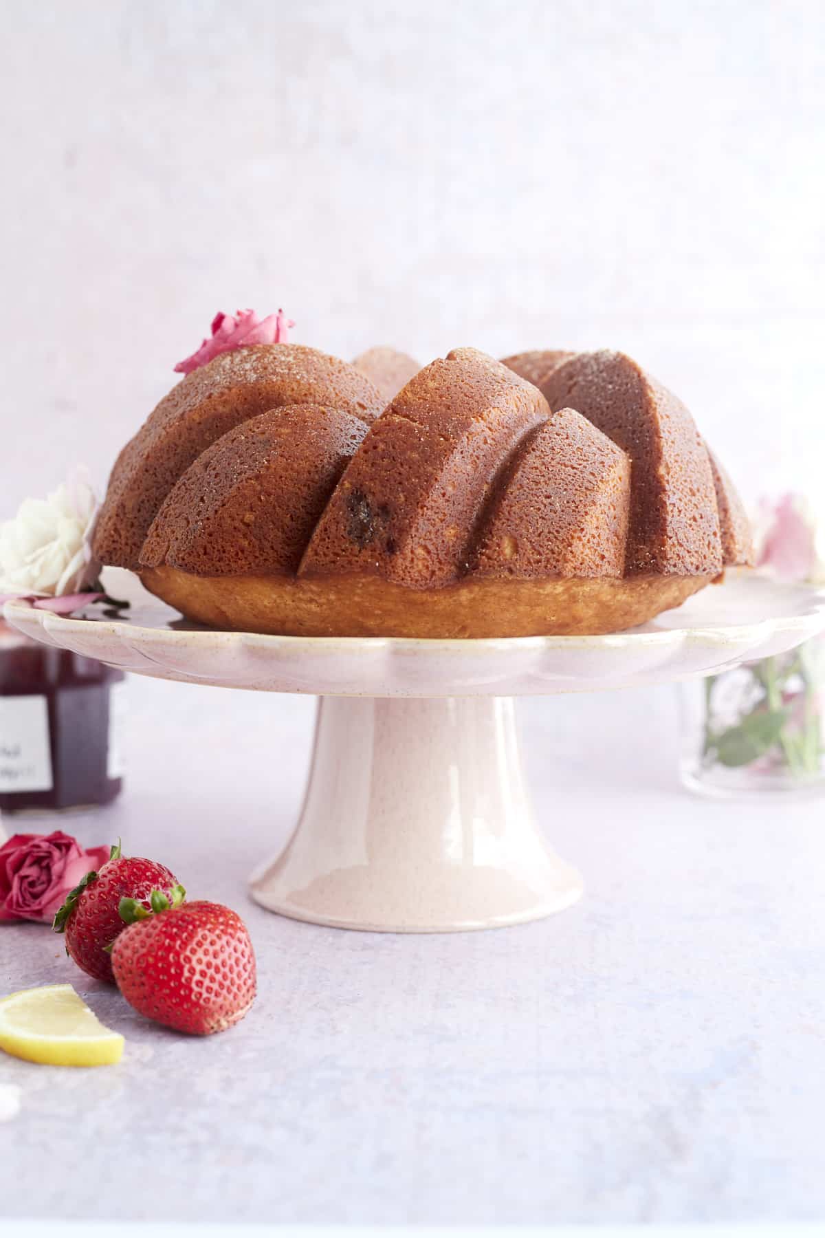 A strawberry lemon bundt cake on a cake stand. 