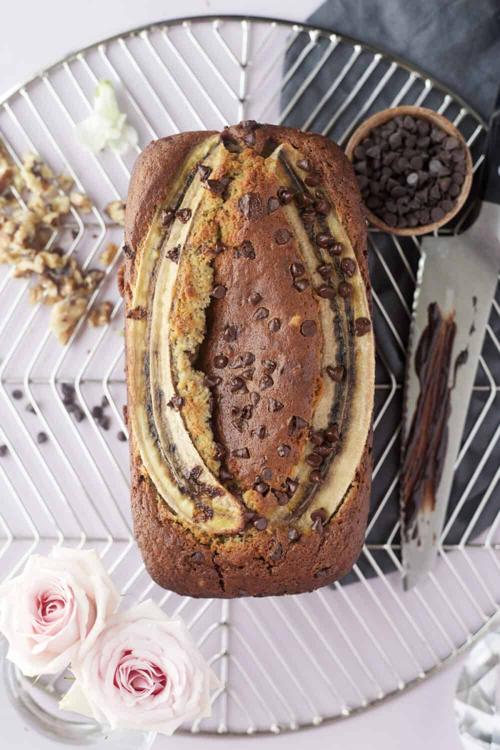 overhead image of banana bread topped with chocolate chips and halved bananas