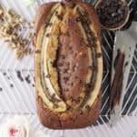 overhead image of a loaf of easy banana bread topped with a halved banana and chocolate chips