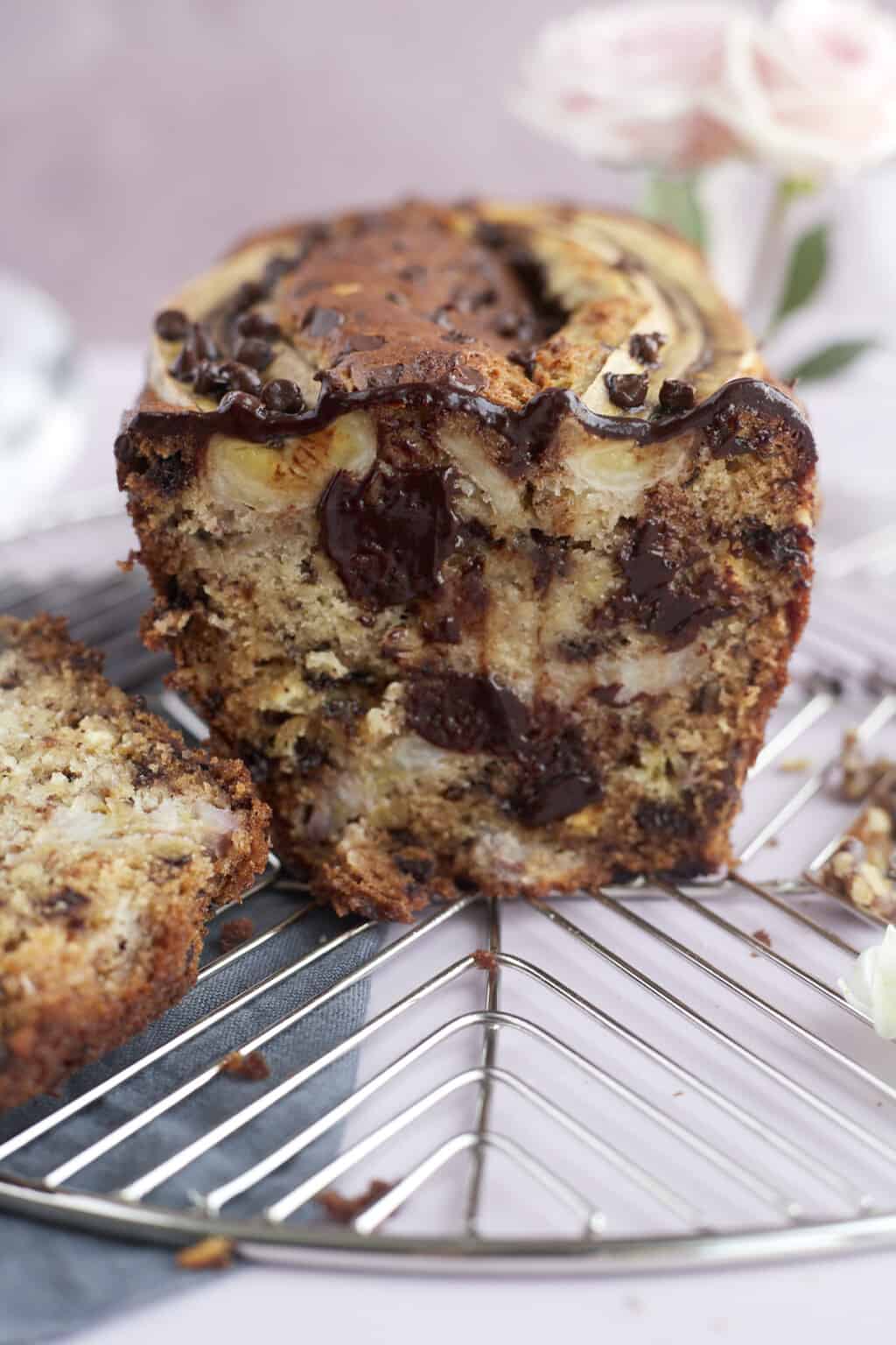 a front view of a sliced loaf of easy banana bread with semi-sweet and white chocolate chips, walnuts, and banana pieces