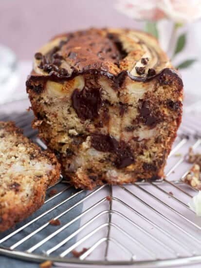 a front view of a sliced loaf of easy banana bread with semi-sweet and white chocolate chips, walnuts, and banana pieces