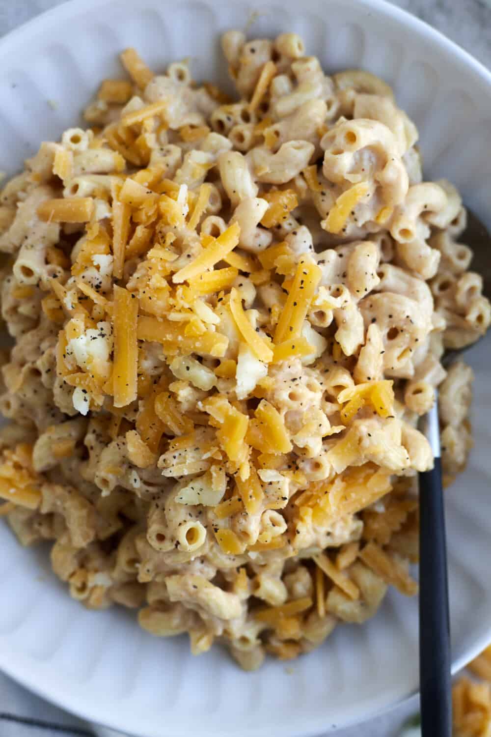 a bowl of crockpot mac and cheese with extra shredded Cheddar on top 