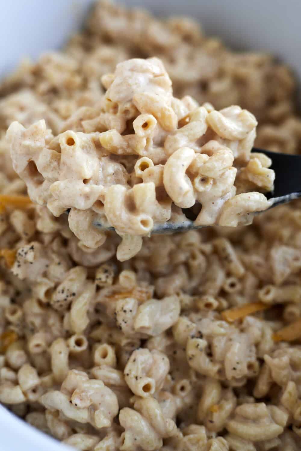 a close up image of a spoonful of crockpot mac and cheese