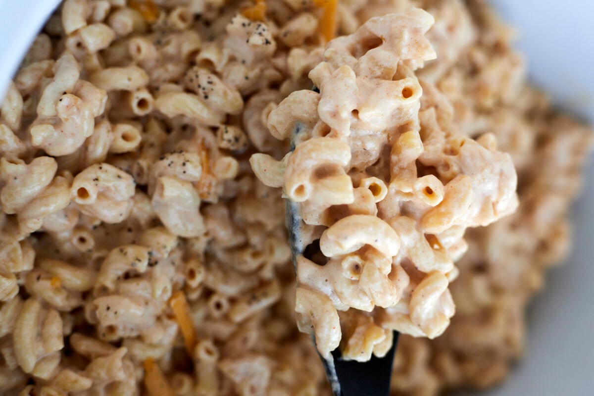 Crockpot mac and cheese being stirred.