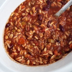 overhead image of pasta and beans soup in a slow cooker