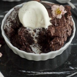a brownie skillet in a white ramekin topped with vanilla ice cream