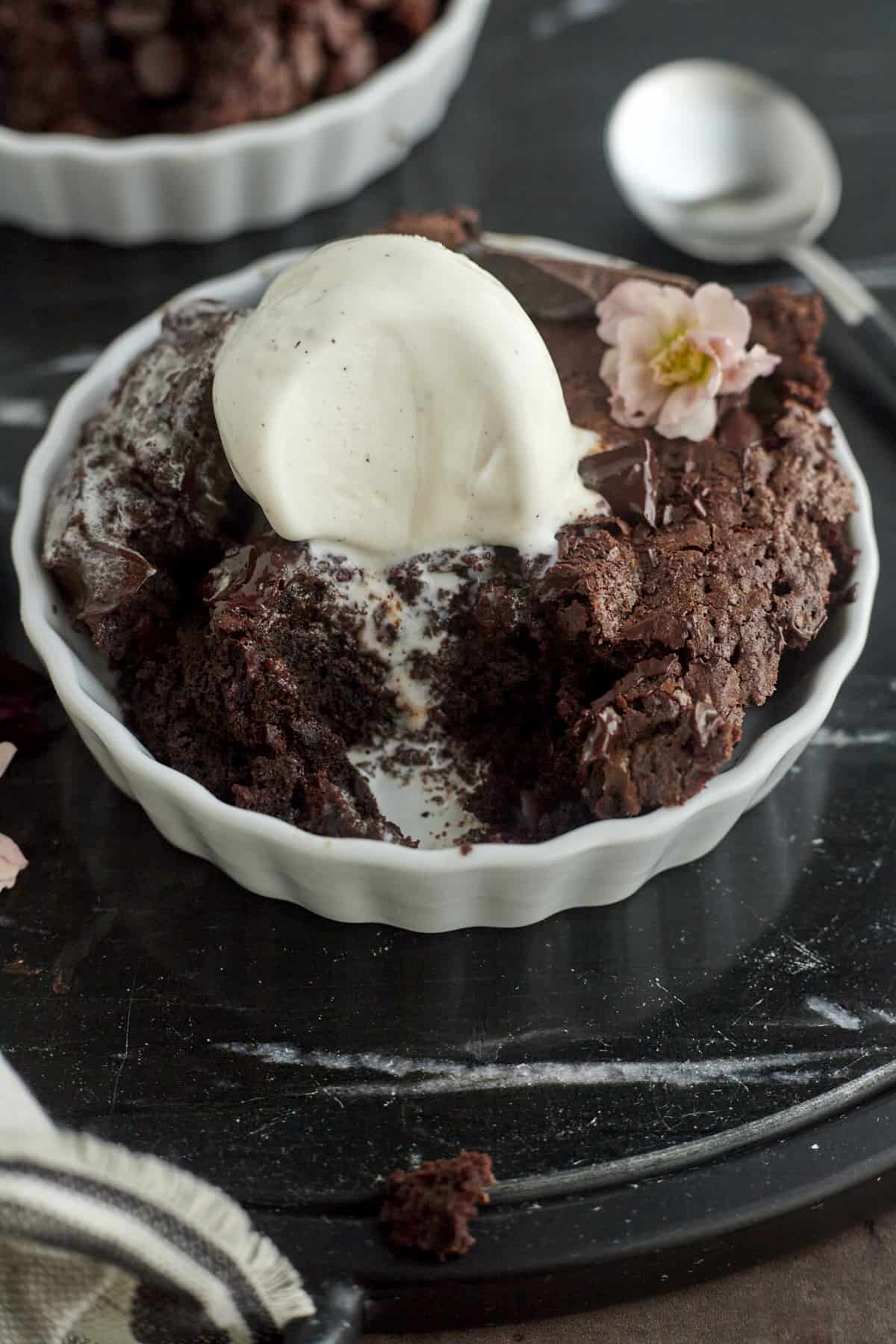 a brownie skillet in a white ramekin topped with vanilla ice cream